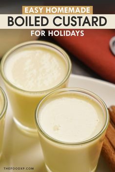 three glasses filled with homemade boiled custard on top of a white plate next to cinnamon sticks