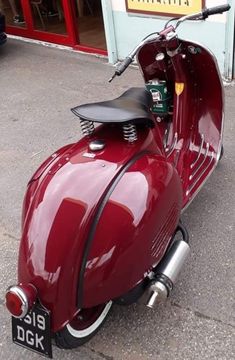 a red scooter is parked on the street