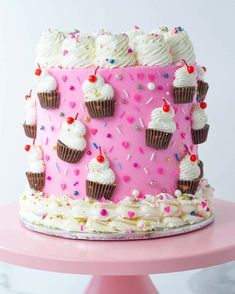 a pink cake with white frosting and sprinkles