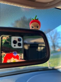 a car mirror with an image of a doll in the rear view mirror