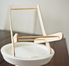 a white bowl sitting on top of a table with wooden sticks sticking out of it