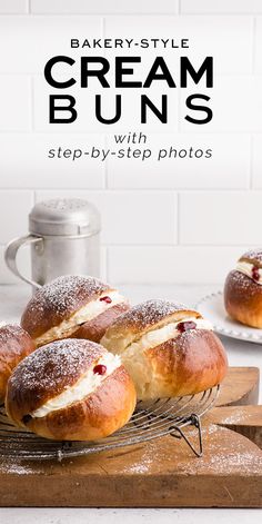 baked creme buns sitting on top of a wooden cutting board