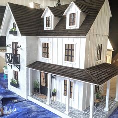 a model house is shown on a table with blue tarp around it and windows