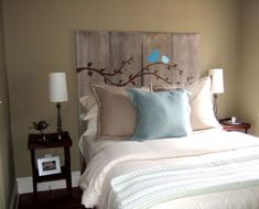 a bed with two blue birds on the headboard and one light brown nightstand next to it