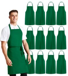 a man wearing an apron and standing in front of a set of green aprons