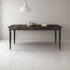 a wooden table sitting on top of a white floor next to a lamp and window