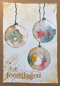 three watercolor ornaments hanging from strings with the words, i like festkagen written on them