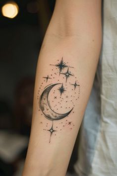 a woman's arm with a crescent and stars tattoo on it