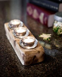 three tea lights sitting on top of a wooden block