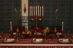 a table topped with plates covered in food and candles