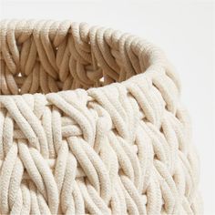 a large white woven basket sitting on top of a table