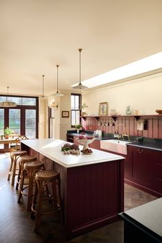 a kitchen with an island, sink and several stools next to the counter top