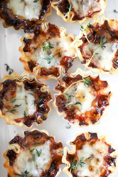 small shells filled with meat and cheese on a white plate next to some parsley