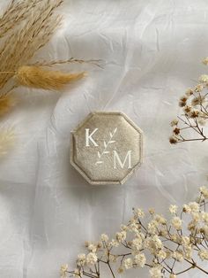 a close up of a flower on a white surface with the letter m in it