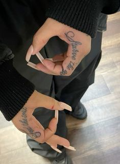 two people with tattoos on their hands and one has the word love written on it