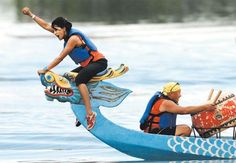 two people riding on the back of a blue boat