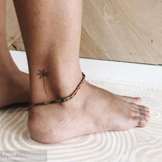 a person with a small tattoo on their ankle and foot is sitting on the floor