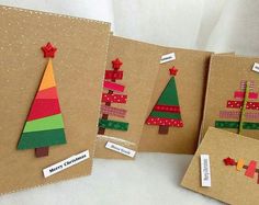 three christmas trees made out of brown paper with red and green ribbons on them, sitting next to each other