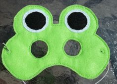 a green felt mask with two eyes on the front and one in the back that is shaped like a dog's paw