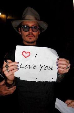 a man holding up a sign that says i love you