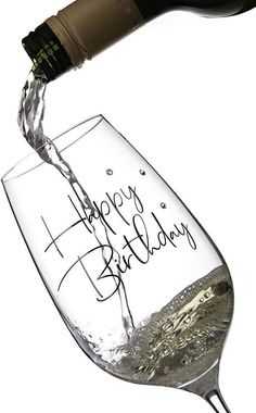 a bottle of wine being poured into a glass with the words happy birthday written on it