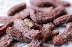 powdered sugar coated donuts on top of a newspaper