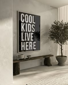 a black and white poster hanging on the wall next to a bench with a potted plant