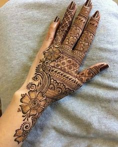 a woman's hand with henna tattoos on it