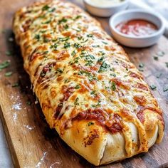 a cheesy bread is sitting on a cutting board