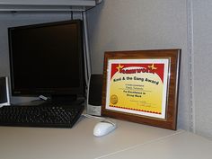 a computer keyboard sitting next to a framed award