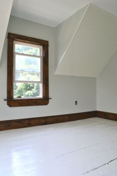 an empty room with white walls and wood trim