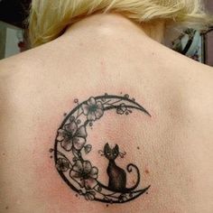 a woman's back with a cat sitting on the moon and flowers around it