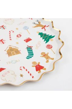 a paper plate with christmas decorations on the side and gold trimmings around it