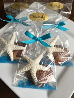 starfish cookies wrapped in cellophane and tied with blue ribbon on a white plate