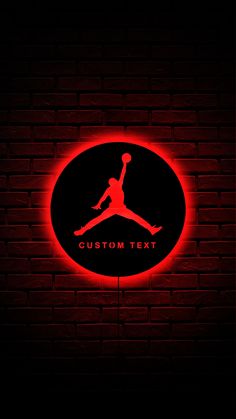 the air jordan logo is lit up on a brick wall with red light behind it