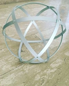 a metal sculpture sitting on top of a marble floor