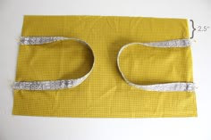 a piece of yellow fabric with silver trim