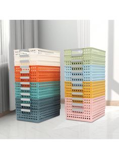 two plastic baskets sitting next to each other on the floor in front of a window