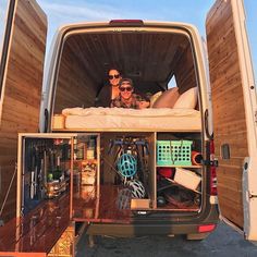 two people sitting in the back of a van