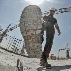 a man standing next to a giant shoe