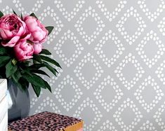 a vase with pink flowers sitting on top of a book next to a leopard print wallpaper