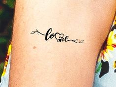 a woman's arm with the word love written in cursive writing on it