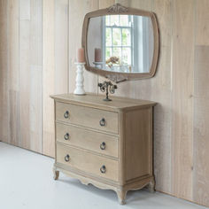 a dresser with a mirror on top of it in front of a wooden paneled wall