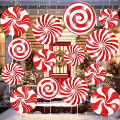 many red and white lollipops hanging in front of a christmas window with snow