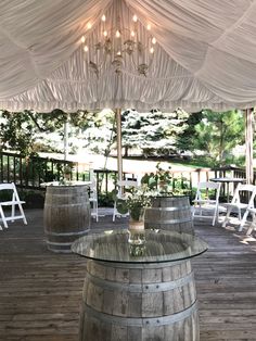 an outdoor venue with wooden barrels and chandelier