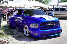 a blue ram truck parked in front of a tent