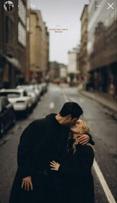 a man and woman standing in the middle of an empty street