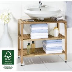 a wooden shelf with towels and soaps on it in front of a white sink