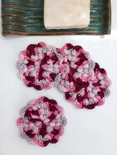 crocheted coasters are sitting on a white surface