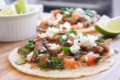 two tortillas topped with meat, cheese and veggies on a cutting board